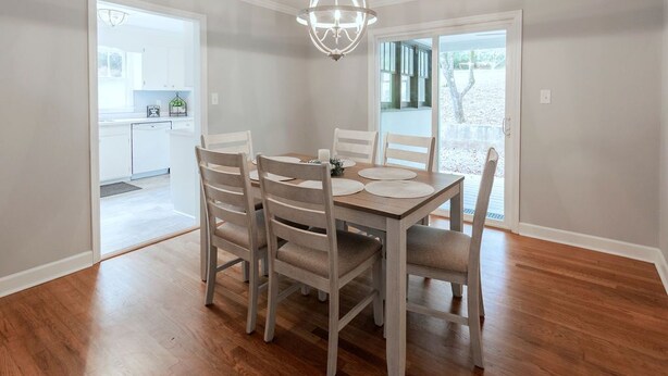 A dining area with a wooden table and chairs, a chandelier, and a view of the outdoors. - Countryside Retreat (Soddy-Daisy)