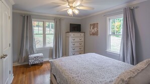 A bedroom with a bed, a dresser, a ceiling fan, and a window with curtains. - Countryside Retreat (Soddy-Daisy)
