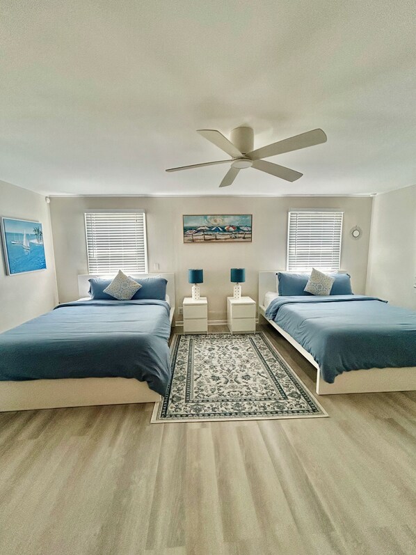A bedroom with two beds, a ceiling fan, and a rug. - Ocean Breeze House - Summer fun Sleeps 8 boating, fishing and 🦞 Lobster season. (Summerland Key)