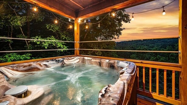 Un jacuzzi con muelle de madera y vista al bosque.