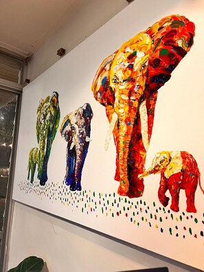 A wall with a colorful, abstract painting of elephants. - UDEE Cozy Hotel (Chiang Mai)