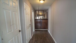 A hallway with white doors, a wooden cabinet, and a ceiling light fixture. - Nice and Cousy guest suite (Roswell)
