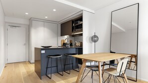 A modern kitchen with a central island, bar stools, and a dining table with chairs. - Creative and Carefree Living (Auckland)