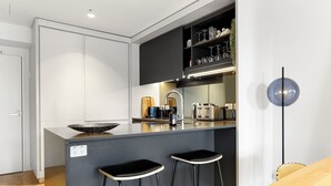 A modern kitchen with a central island, bar stools, a coffee machine, and a wine rack. - Creative and Carefree Living (Auckland)