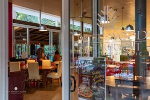 A restaurant with a modern interior, large windows, and hanging pendant lights. - Ocean House - 4 BR w/ Private Pool - 100m to Beach (Agnes Water)