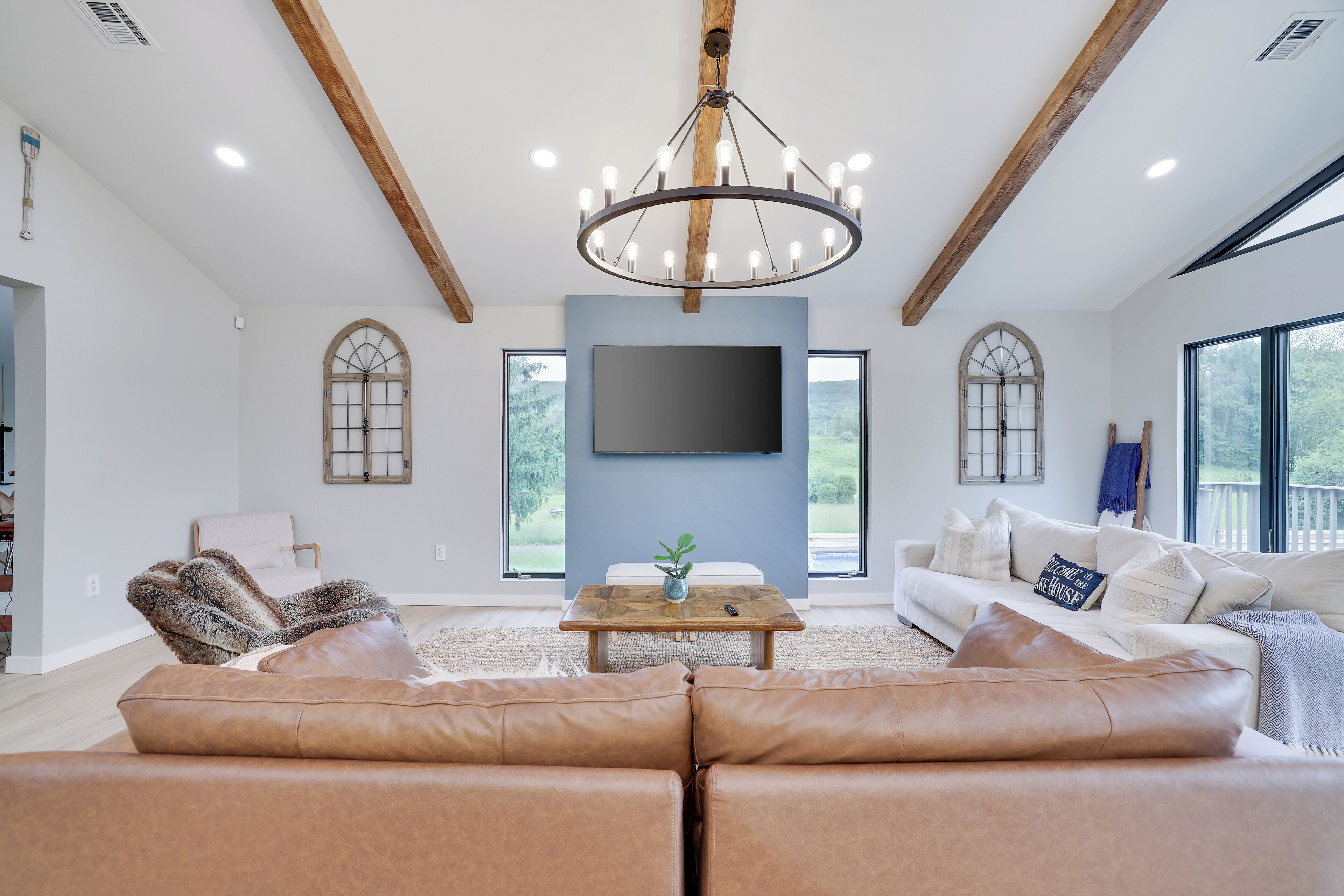 A spacious living room with a large sofa, a coffee table, and a chandelier.
