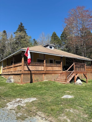 Eine Lodge mit einer Holzterrasse, einer Flagge und einem Schild, das anzeigt, dass es sich um eine Lodge handelt.