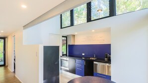 Una cucina moderna con forno integrato, macchina da caffè e un faretto a parete.