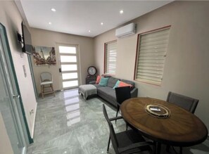Relax in this stylish living area with a comfortable sofa, dining table, and flat-screen TV.