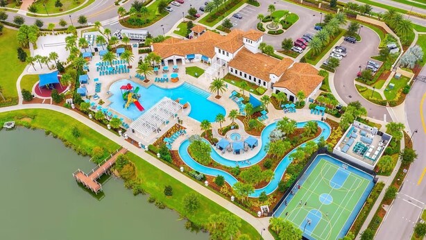 Eine Vogelperspektive eines Resorts mit einem zentralen Pool, einem Tennisplatz und einem Steg.