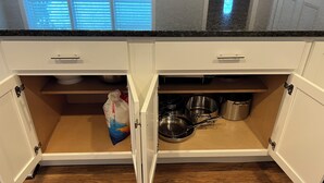 A kitchen with white cabinets, a granite countertop, and a window with blinds. - Cheerful 2 Home (Riviera Beach)