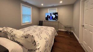 A bedroom with a bed, a dresser, a TV, and a desk. - Cheerful 2 Home (Riviera Beach)