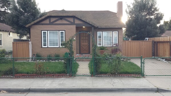 A two-story house with a brown exterior, a front door, and a small porch.