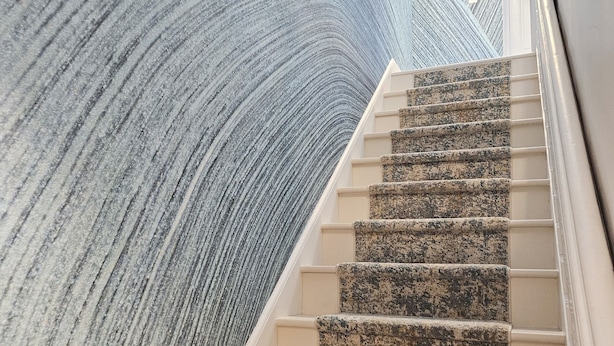 Eine Treppe mit einem einzigartigen, gebogenen Wanddesign.