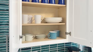 Eine Küchenschrank mit blauen und weißen Tassen, Tellern und Schüsseln.