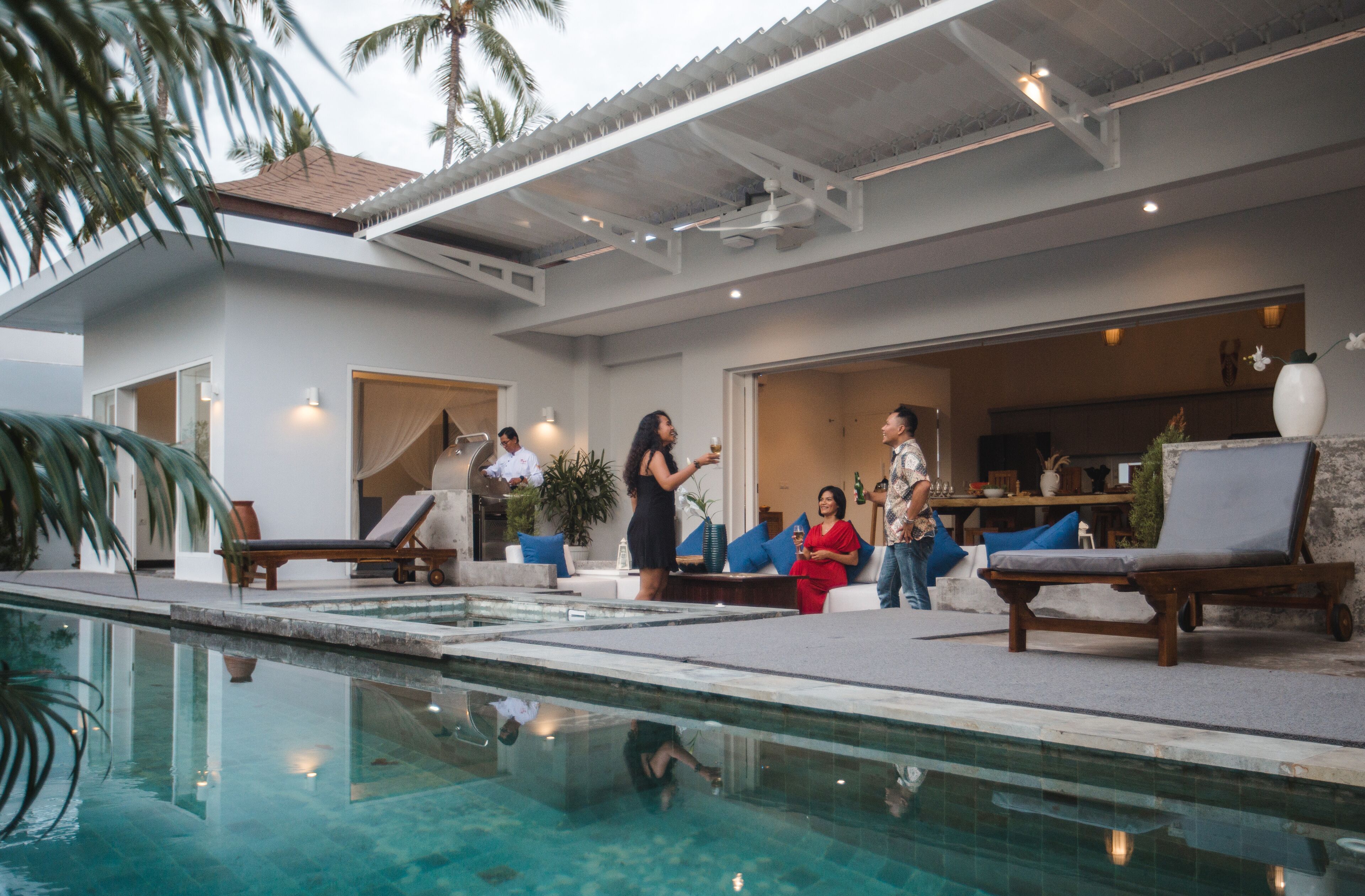 A pool area with lounge chairs and a dining area.