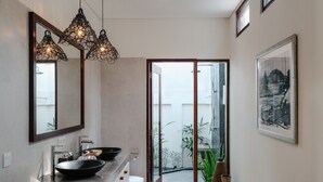 A modern bathroom with a large mirror, two sinks, and a large window.