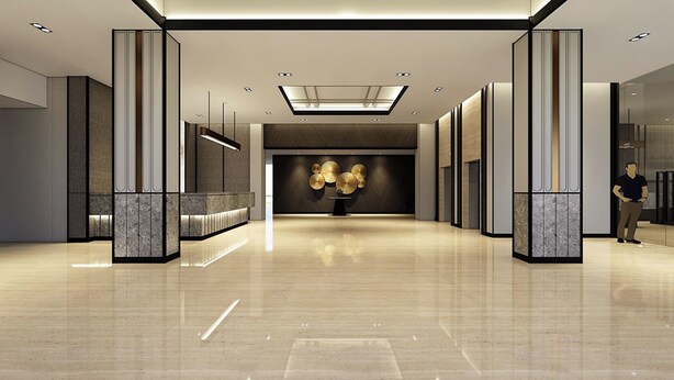 Een moderne hotel lobby met een centraal gelegen receptiebalie, een decoratieve wand met cirkelvormige patronen en een gepolijste marmeren vloer.