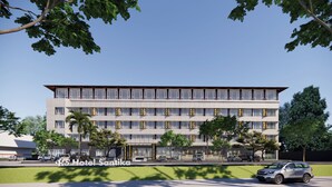 Een modern hotel met een plat dak, meerdere verdiepingen en een centrale ingang.