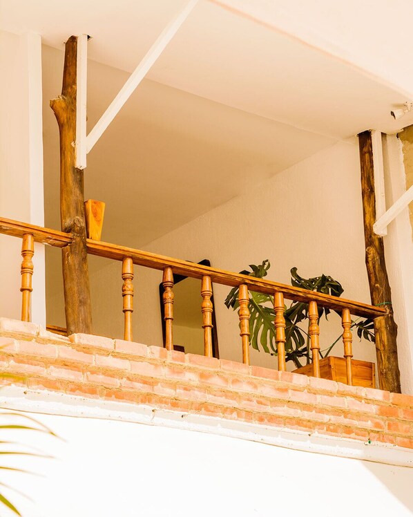 A wooden staircase with a brick wall. - HOSTAL LA BOQUILLA (Cartagena)