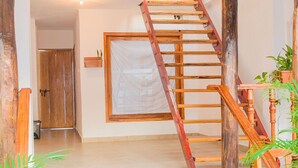 A wooden staircase with a handrail, a wooden door, and a window with a white curtain. - HOSTAL LA BOQUILLA (Cartagena)