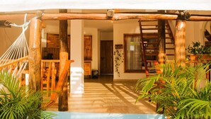 A wooden staircase leading to a covered outdoor area with a hammock and potted plants. - HOSTAL LA BOQUILLA (Cartagena)