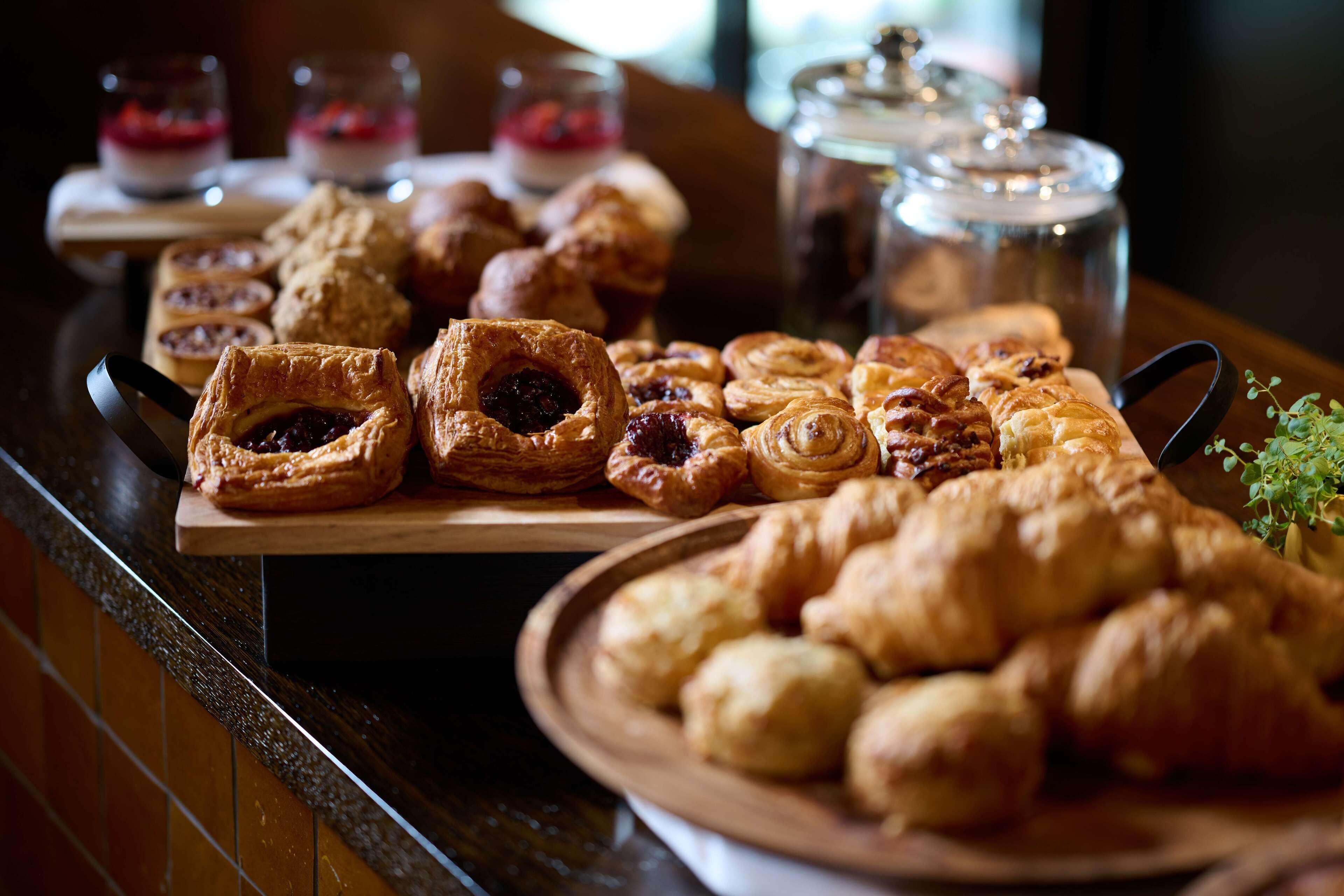 A variety of pastries and desserts on a wooden serving board.