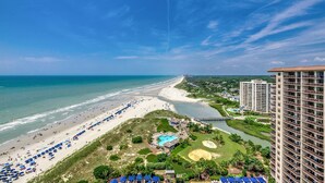 A coastal resort with a beach, a golf course, and a river.