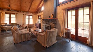 Una sala de estar acogedora con sofás a rayas, una mesa de madera y una chimenea de piedra.