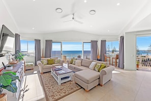 Relax in this stylish living room with a large sectional sofa, coffee table, and flat-screen TV.