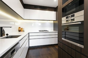 Features an oven, stainless steel sink, and a large window.