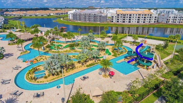 Ein Resort mit großem Schwimmbecken, Wasserrutsche und Seeblick.