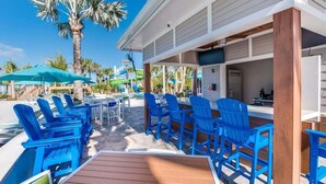 Ein Poolbereich mit blauen Stühlen und einer Bar.