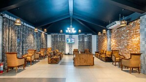A spacious lobby with a high ceiling, patterned curtains, and a central seating area with sofas and chairs. - Shaira Garden Resort (Bandar)