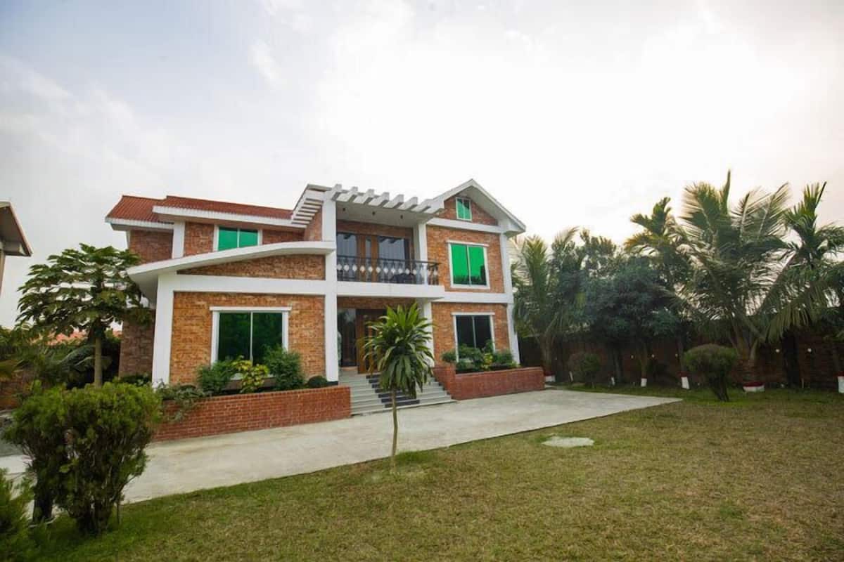 A two-story house with a balcony, brick exterior, and green shutters.