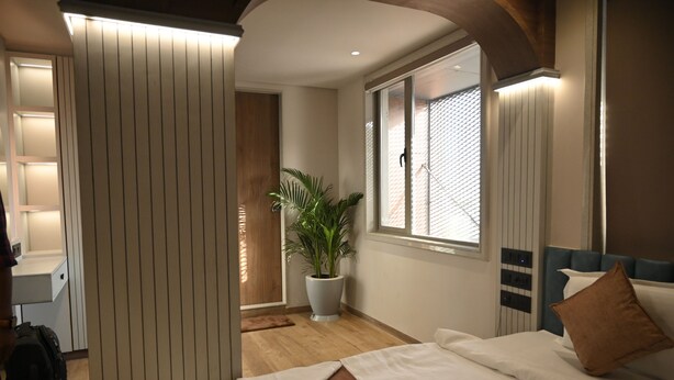 A modern hotel room with a bed, a potted plant, and a desk. - JVL By Nexottel (Rajkot)