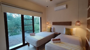 Une chambre d’hôtel avec deux lits, un ventilateur de plafond, un appareil de climatisation et une vue sur l’extérieur.