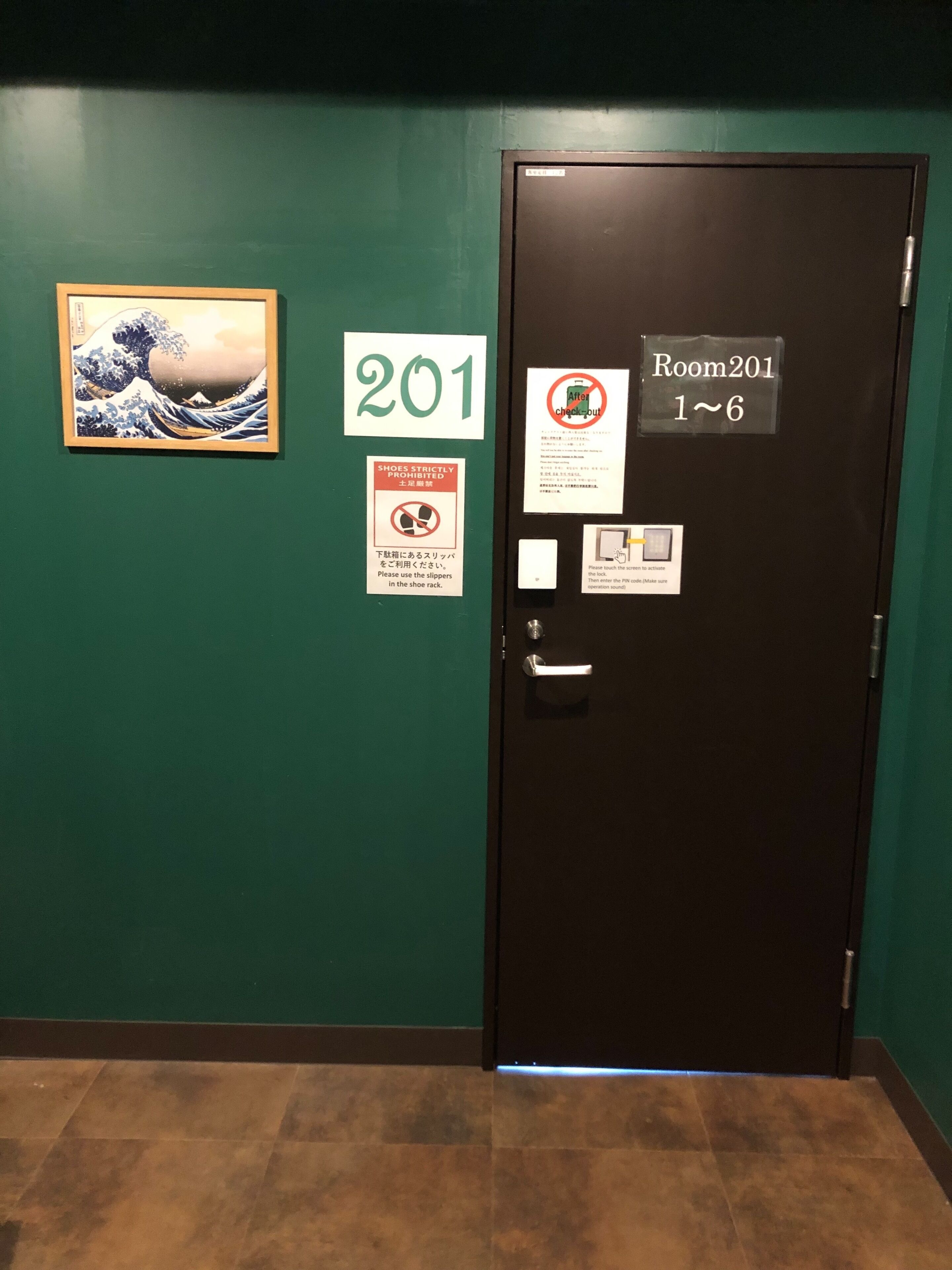 A hotel room door with a sign indicating Room 201, accessible from 1 to 6.