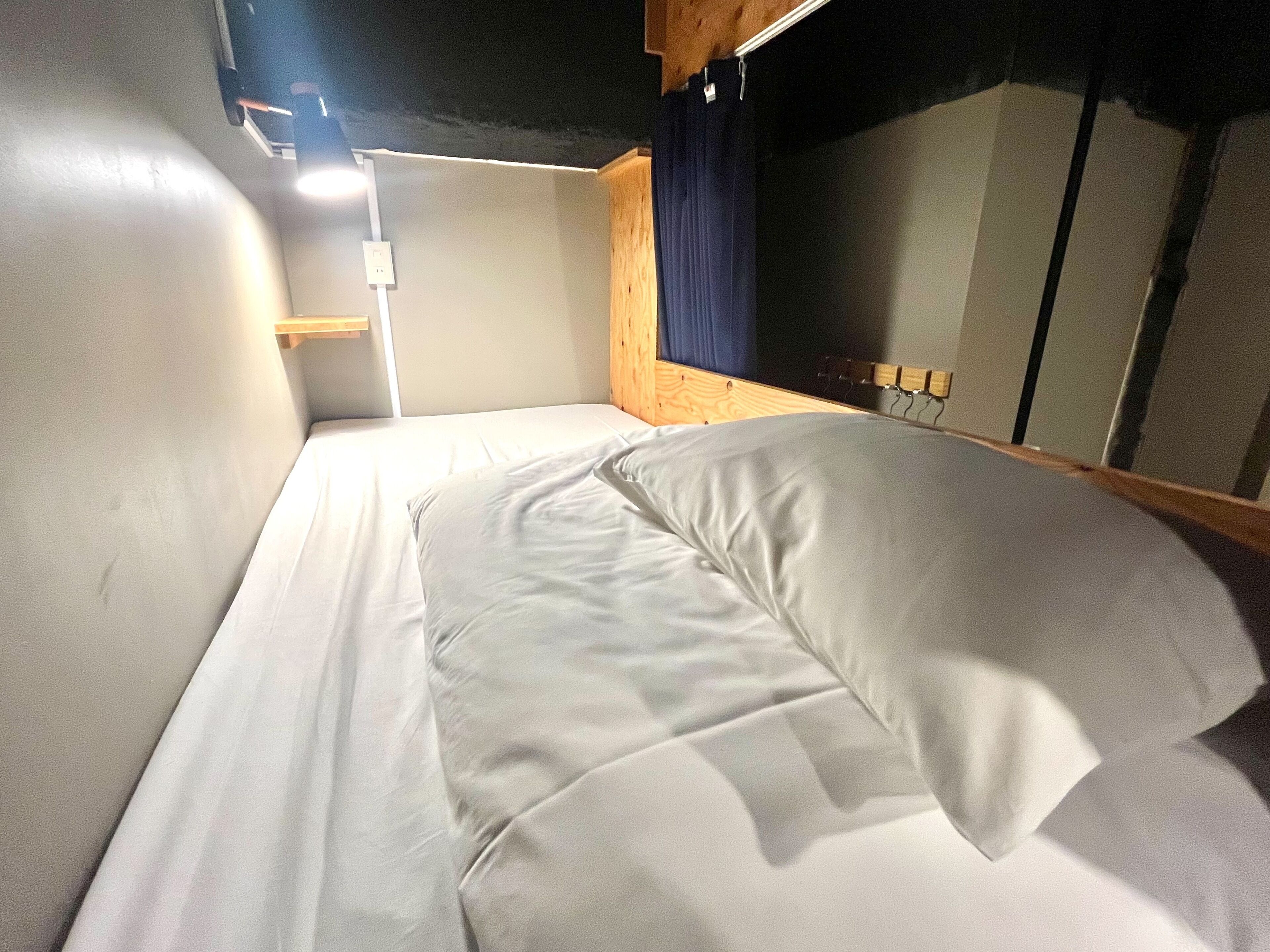 A bunk bed with white bedding and a wooden headboard.