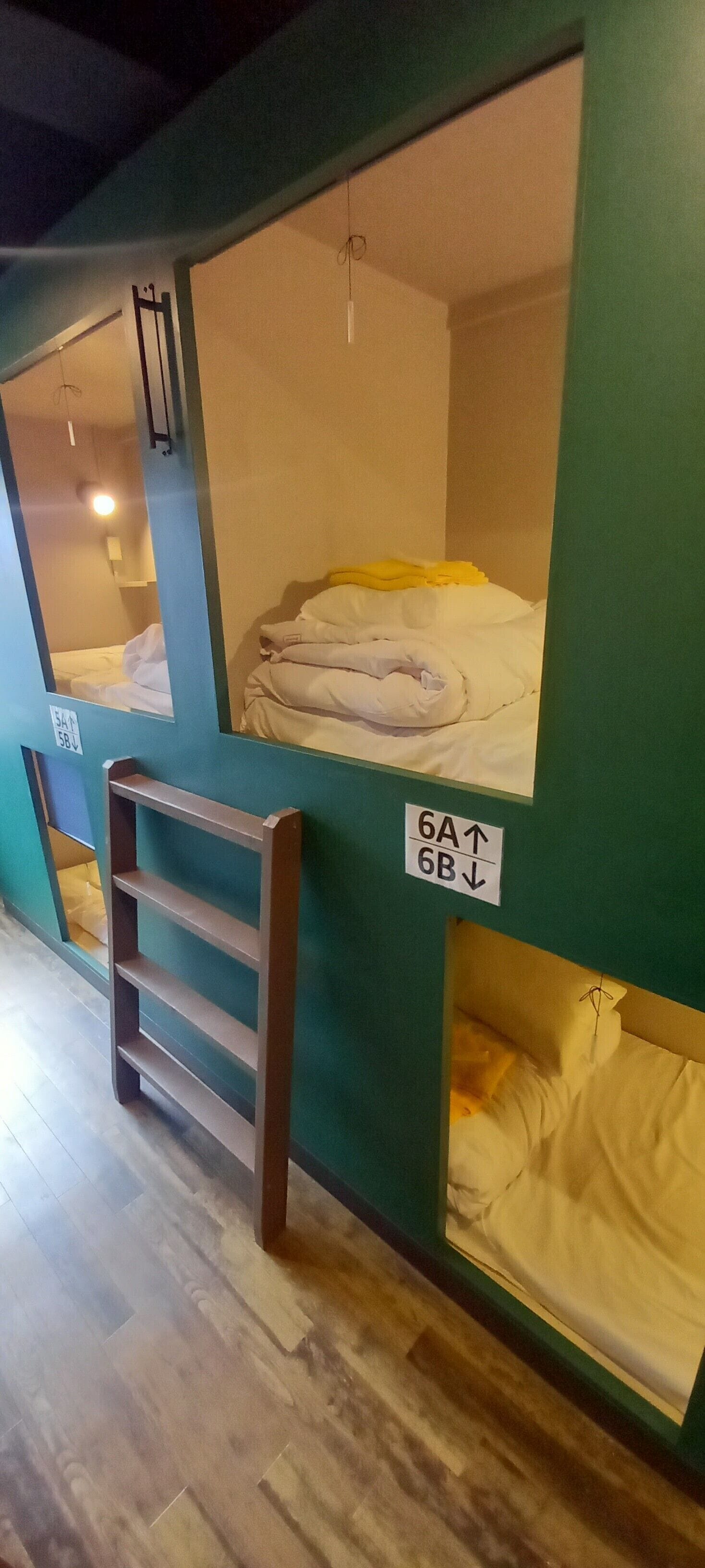 Des lits superposés avec une pancarte indiquant les numéros de chambre 6A et 6B.