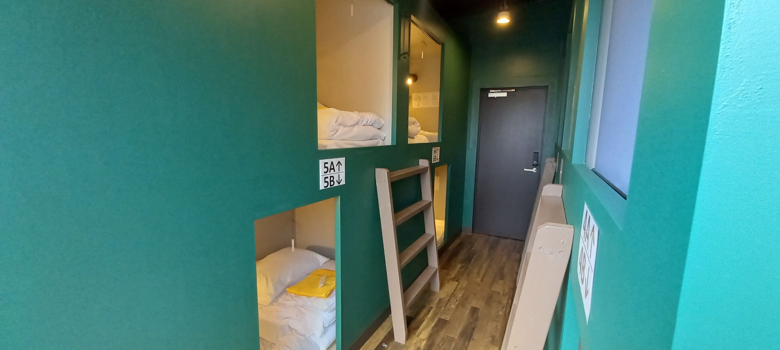 A narrow hallway with bunk beds and a door.