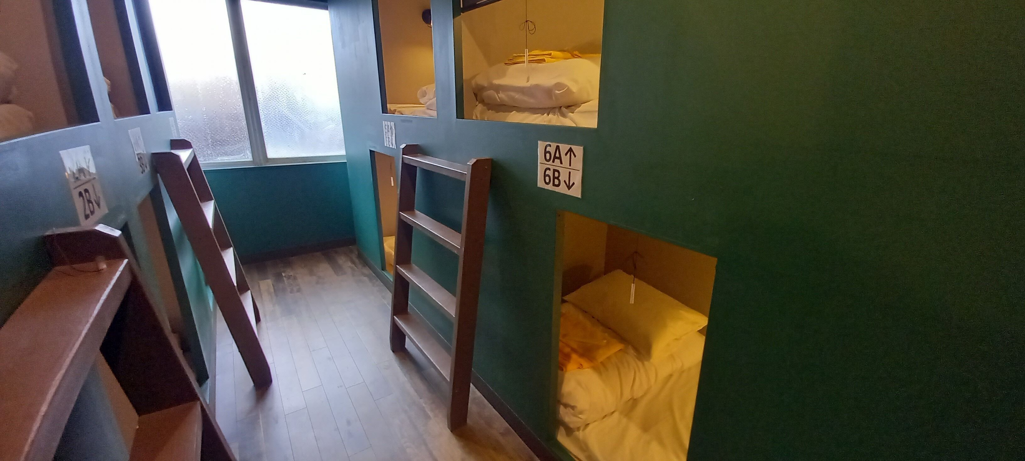 Un dormitorio con literas, una escalera y una ventana.