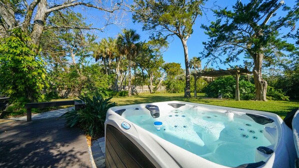 A hot tub in a garden with trees and a wooden deck. - Villa Solano| Holiday deals, book now! (Downtown St. Augustine)