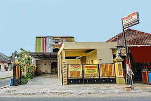 Un edificio con un letrero que dice "PENGINAPAN MUTIARA" y "RUMAH KOS", indicando un centro de negocios o de servicios.