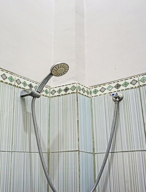 Ducha con cabezal de ducha de mano y dos cabezales fijos.