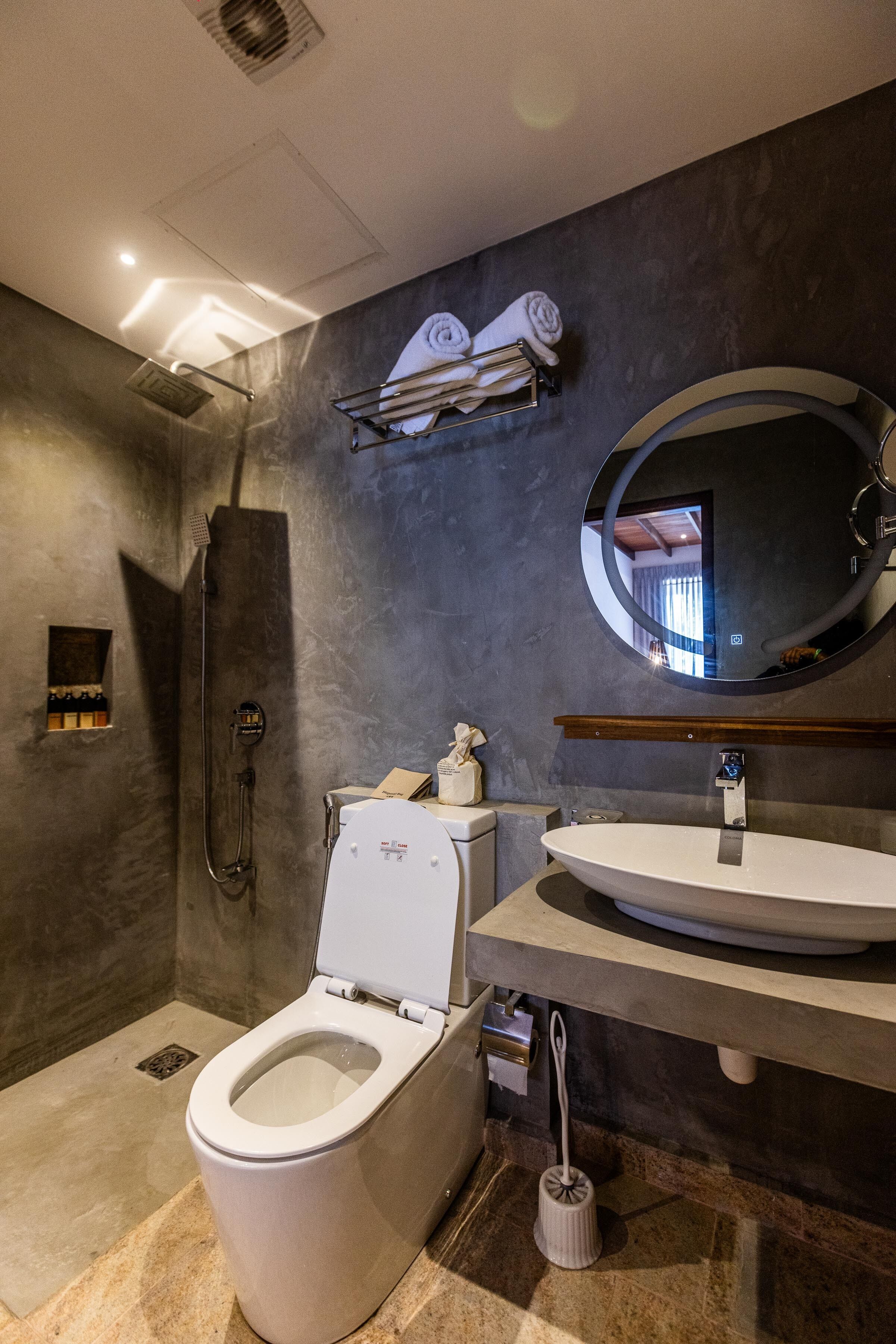 A modern bathroom with a shower, toilet, and sink.