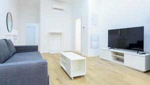 A modern living room with a grey sofa, a white entertainment unit, and a flat-screen TV. -  Bieti Castellon (Castelló de la Plana)