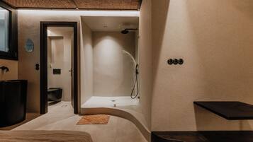 Relax in a spacious bathroom with a large curved bathtub, separate shower area, and a vanity with mirror.