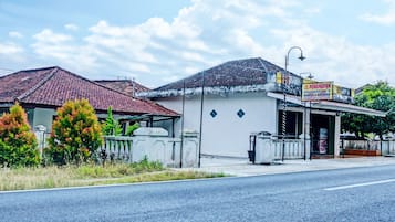 A building with a tiled roof and a signboard.