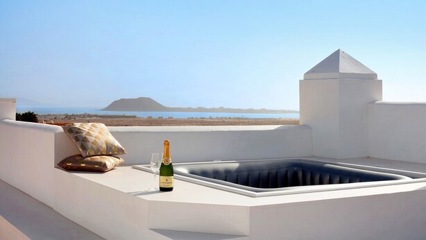 A rooftop terrace with a hot tub, a bottle of champagne, and two pillows. - Luxury Ocean View holiday home with sea view and shared pool (Corralejo)